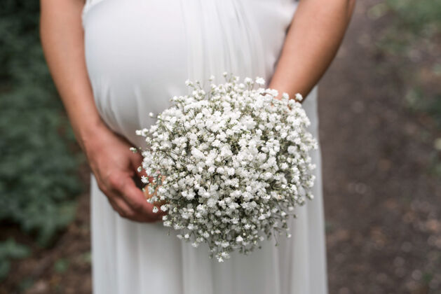 优雅一个怀孕的新娘在婚礼上手持花束的特写镜头仪式活动浪漫