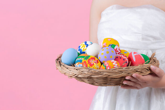 兔子微笑着 戴着兔子耳朵 拿着粉色背景的复活节彩蛋的年轻女子黑发服装情感