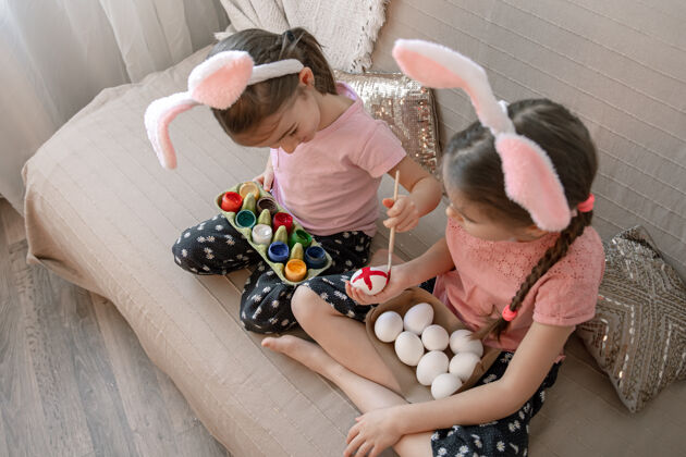 孩子小妹妹们在家里的沙发上画复活节彩蛋房子妹妹顶视图