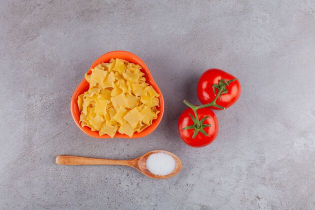 食物一碗未煮熟的意大利面配上新鲜的西红柿和盐团体饮食有机