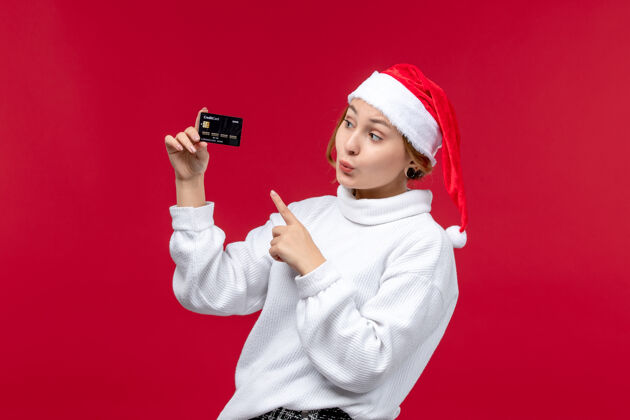 卡片正面图红色背景上手持银行卡的年轻女性钱肖像正面