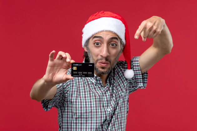钱正面图：年轻男性在红色背景下展示银行卡正面卡片男人
