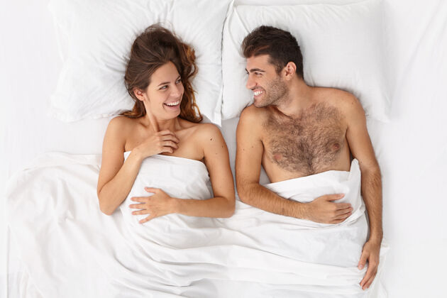 毯子特写这对躺在床上白毯子下的夫妇新婚夫妇快乐睡眠