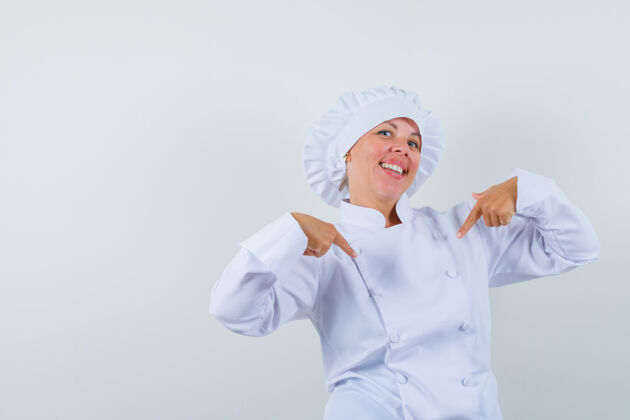女性女厨师指着自己穿着白色制服 看上去很自豪眼睛自信现代