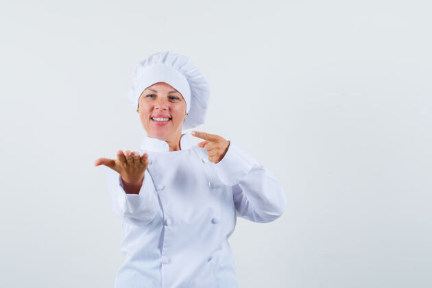 女人一位身穿白色制服的女厨师指着手上的东西 神情专注看年轻指向