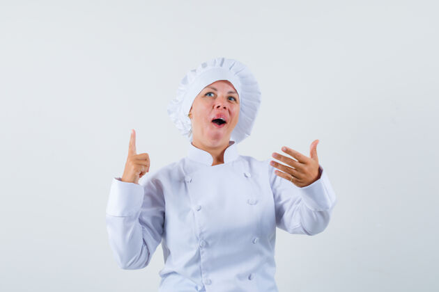 时尚穿着白色制服的女厨师在菜单上摆出一副挑选食物的姿势粉色乐趣年轻