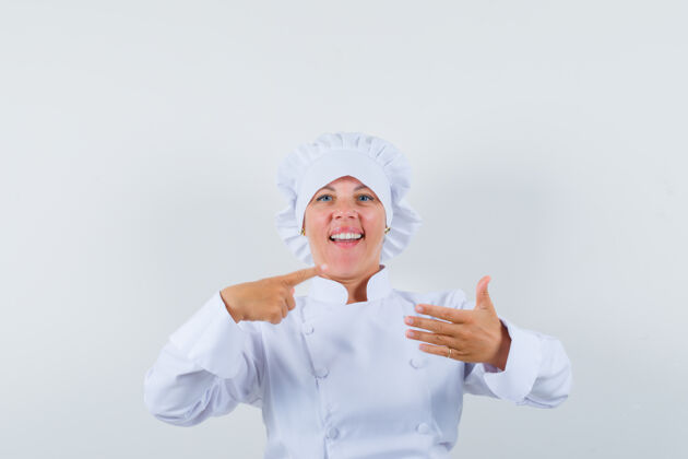 可爱穿着白色制服的女厨师指着一边 假装拿着什么东西 看起来很自信制服指向乐趣