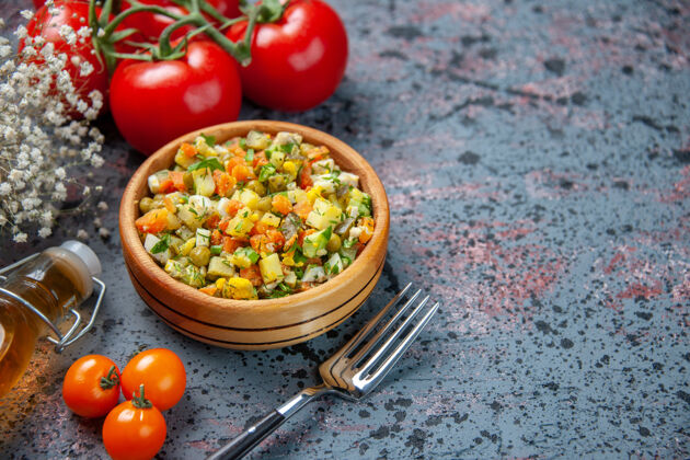 调味品前视图蔬菜沙拉与调味品蓝色背景西红柿健康蔬菜沙拉