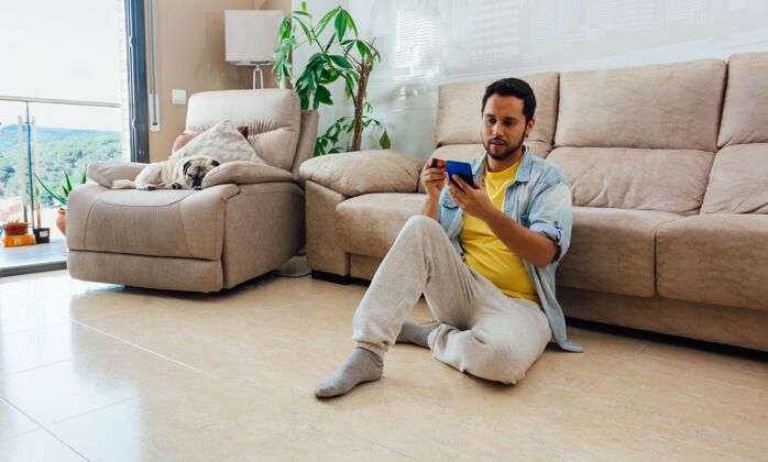 技术一个男人坐在家里的地板上用手机拍摄的大幅面照片女性成年人电话