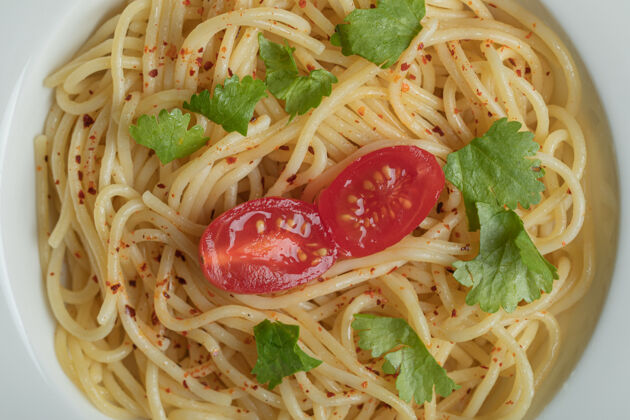 顶视图美味的意大利面配上绿色蔬菜和樱桃番茄蔬菜可食用一餐