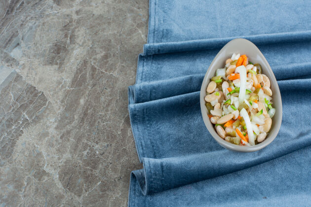 美味一碗蔬菜沙拉放在大理石上的布料上美味碗蔬菜