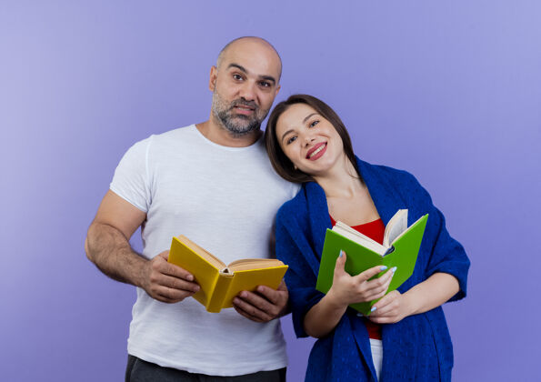 紫色一对幸福的成年夫妇 裹着披肩的女人 手里拿着书 看着书包装披肩快乐