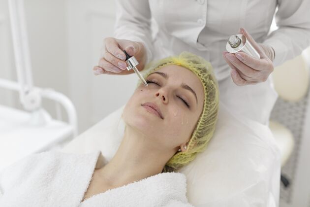 面部治疗在美容诊所做面部护理的女人治疗美容常规客户