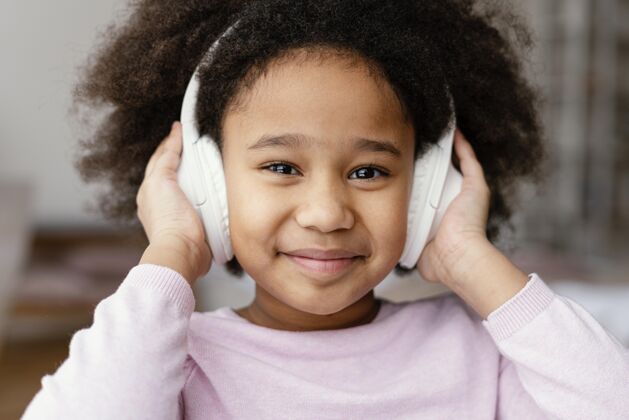 小玩意戴着耳机的小女孩科技室内耳机