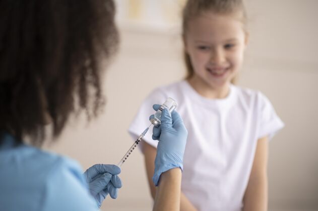 保健年轻医生给小女孩打疫苗危险冠状病毒诊所