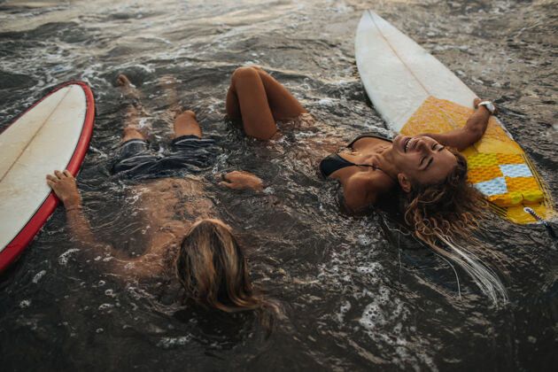 男性一对夫妇拿着冲浪板在水里休息夏天女人大海