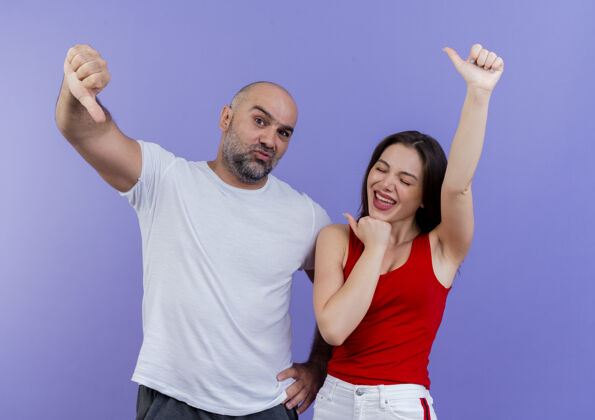 男人成年夫妇自信的男人手放在腰上 快乐的女人闭着眼睛都竖起大拇指展示向上手