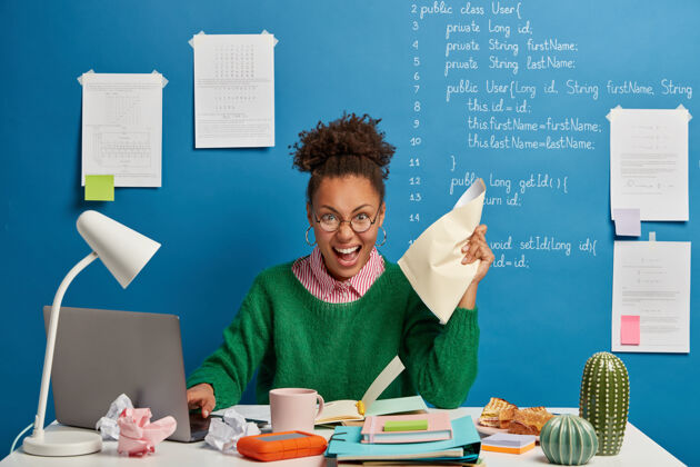 自由职业者情绪化的黑皮肤女文案手揉文件 在现代笔记本电脑上工作 在记事本上写下信息女人写作工人