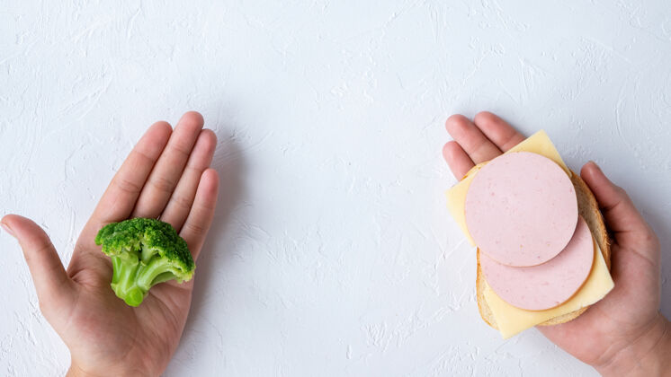 蔬菜两只手拿着花椰菜和三明治健康食品的主意背景光豌豆生菜饮食