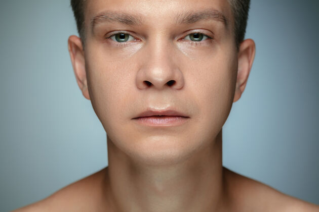 皮肤隔离在灰色墙壁上的赤膊青年的肖像白人健康男模看镜头摆姿势男人的健康和美丽 自我保健 身体和皮肤护理的概念清洁卫生年轻