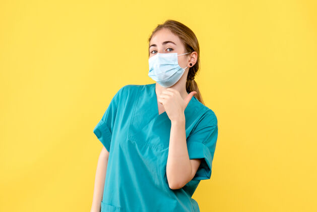 微笑黄色桌子上戴着口罩的女医生卫生院大流行病毒脸成人医院