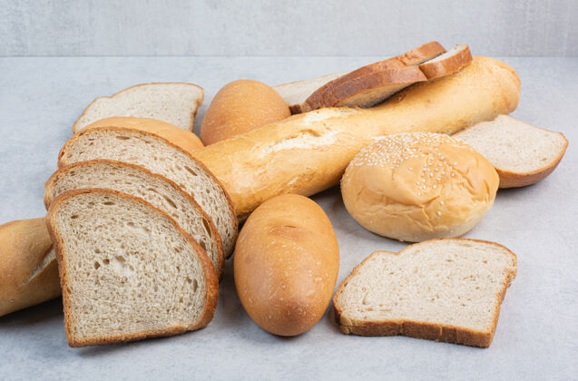 食品一堆新鲜的面包在大理石背景上高质量的照片法式面包卷切片