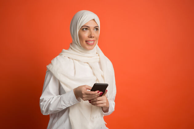 伊斯兰快乐的阿拉伯女人戴着头巾拿着手机面部人类