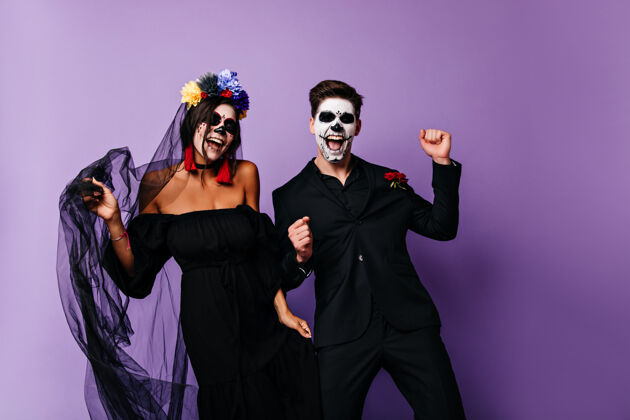 死亡穿着黑色衣服的积极吸血鬼一起跳舞微笑的墨西哥穆尔特夫妇在紫色背景上摆姿势传统亡之日