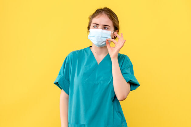 成人正面图黄色背景上戴无菌口罩的女医生医院健康病毒-大流行氧气面罩人大流行