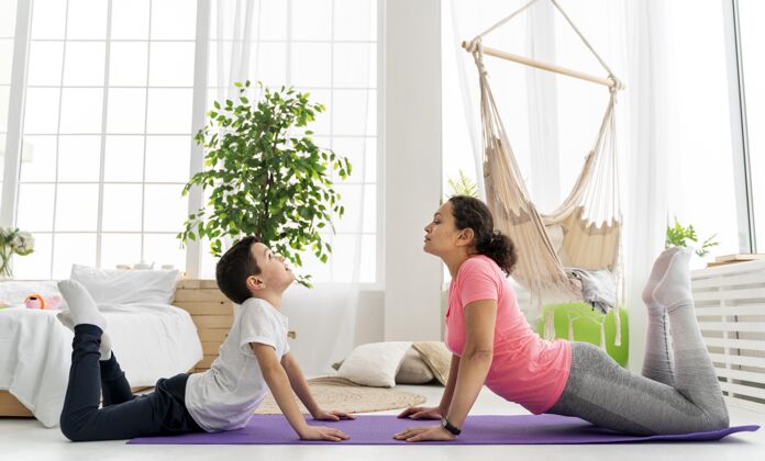 运动全镜头的女人和孩子在瑜伽垫上全场儿童锻炼