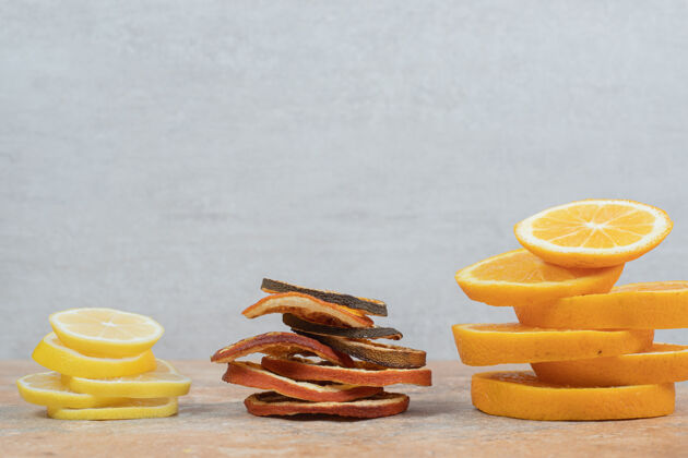 酸新鲜和干燥的柠檬和橙子片放在大理石桌上高质量的照片有机干新鲜