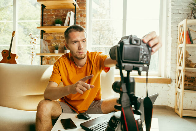 博客年轻的白人男性博主用专业相机录制视频评论家里的小玩意节目技术技术