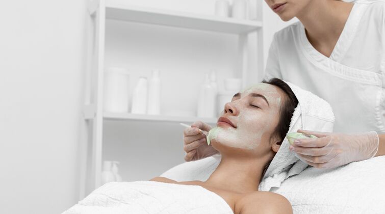 女人在美容院做面部护理的女人客户化妆品沙龙