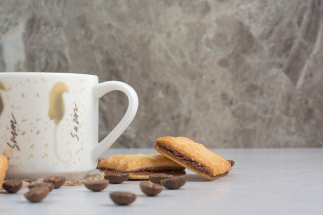 饼干白色背景上有饼干和咖啡豆的白色咖啡杯高品质照片咖啡热的杯子