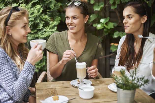 现代和朋友一起喝咖啡的女人坐着休闲微笑