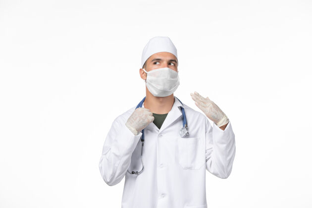 西装正面图：男医生穿着医疗服 戴着防冠状病毒口罩-白墙上的冠状病毒-病毒药大流行医生穿着男人