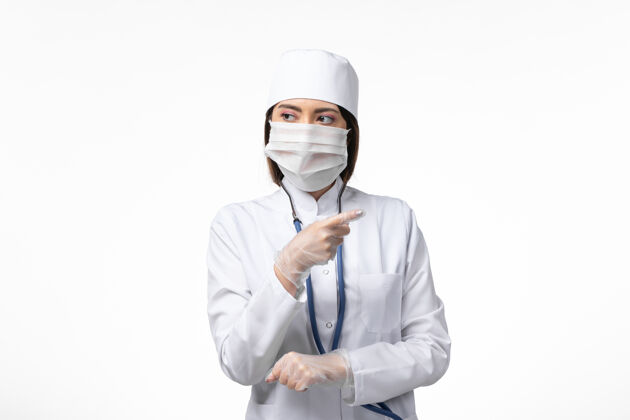 医疗前视图：女医生穿着白色医疗服 戴着口罩 因白墙大流行疾病大流行服装医院大流行