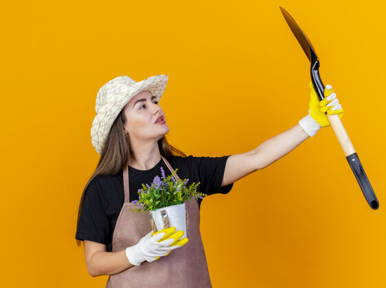 花园漂亮的园丁女孩穿着制服 戴着园艺帽 戴着手套 手里拿着花盆里的花花盆橘子制服
