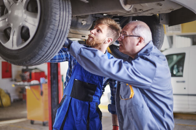 教学修理工在车间里修理汽车服务车轮汽车