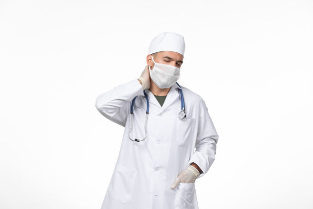 专业正面图：男医生穿着医疗服 戴着防毒面具 在光墙上防治冠状病毒药物大流行冠状病毒病毒防护