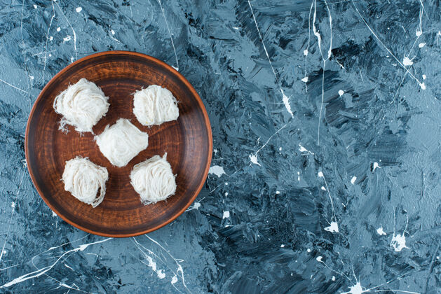传统传统的土耳其棉花糖放在蓝色的木制盘子上美味美味棉花糖