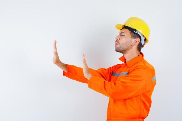 工业建筑工人穿着制服 戴着头盔 神情烦躁 双手保护着自己工头职业保护