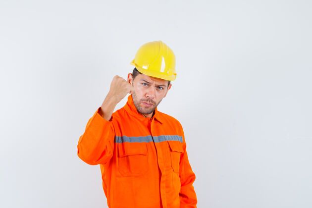 建设者身穿制服的施工人员握紧拳头 头戴钢盔 看上去自信满满 前视尽收眼底土建拳头设备
