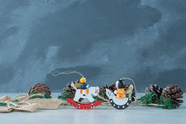 节日松果与小圣诞玩具大理石背景高品质的照片小圣诞树五颜六色