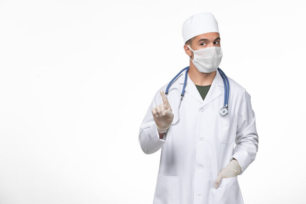 专业正面图：男医生穿着医疗服 戴着防冠状病毒口罩在白色地板上-冠状病毒疾病隔离大流行外套实验室外套对抗