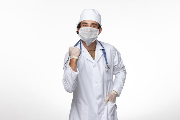 防护正面图身穿医疗服的男医生戴着无菌口罩 以防白墙病毒病的传播消毒冠状病毒医生
