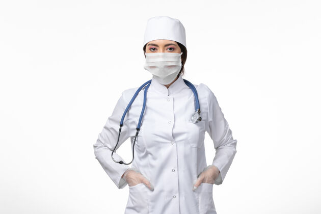 人正面图女医生穿着白色无菌医疗服 戴着口罩 因柯维德病毒在白墙上冒充疾病病毒柯维德病毒大流行面罩到期医生
