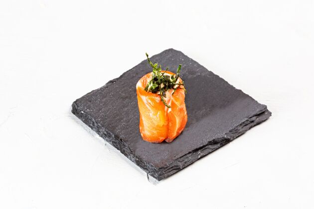 亚洲特写镜头的寿司卷在一个黑色的石头盘子鱼食物晚餐