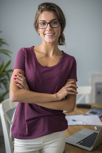 眼镜在家里办公室工作的女人的画像工作办公室内部站立