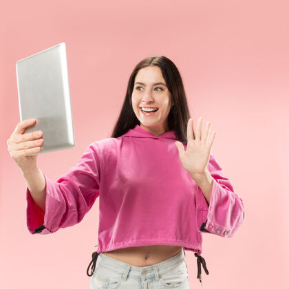 女性带笔记本电脑的女商人热爱电脑概念迷人的女性半身正面肖像 时尚的粉色背景科技电脑程序员